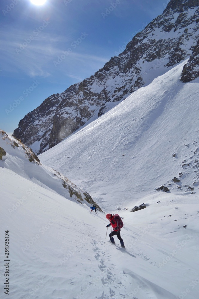 Tatra mountains, Slovakia - FEBRUARY 23, 2019: Young girl is climbing to the summit of Koprovsky Stit. Rising through the snow with cats and wands high in the mountains. Tatra mountains, Slovakia - FEBRUARY 23, 2019: Young girl is climbing to the summit of Koprovsky Stit. Rising through the snow with cats and wands high in the mountains.