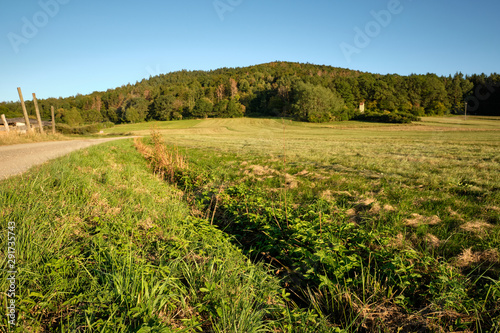 Beautiful late summer landscape in the countryside with a gravel road, meadows and the hill called Moritzberg near Haimendorf, Germany