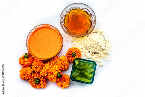 Marigold face mask for sensitive skin isolated on white consisting of some honey, marigold flowers, aloe vera gel, and some chickpea flour or gram flour or besan along with entire constituents. photo