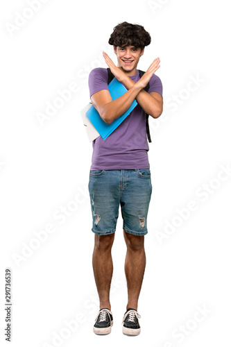 A full-length shot of a Young student man making NO gesture over isolated white background © luismolinero