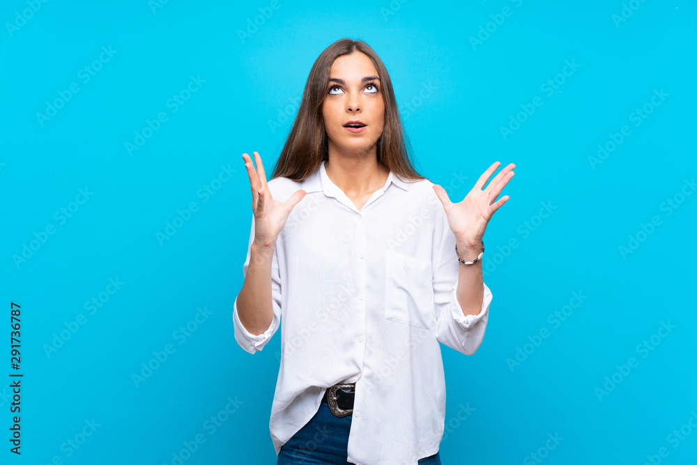 Young woman over isolated blue background frustrated by a bad situation Young woman over isolated blue background frustrated by a bad situation