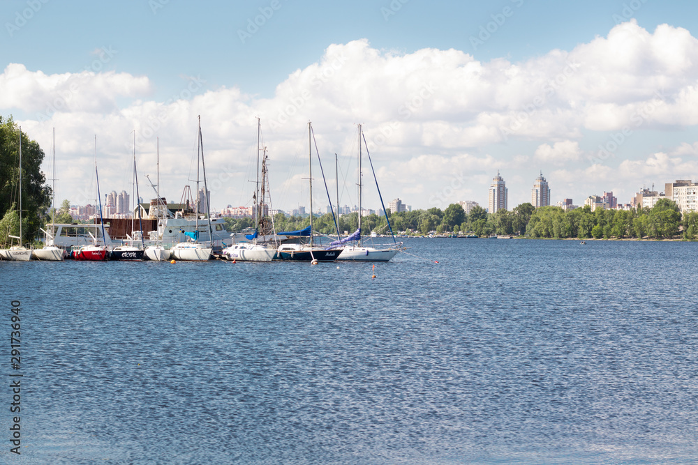 Small city marina on river with sailing yachts and boats