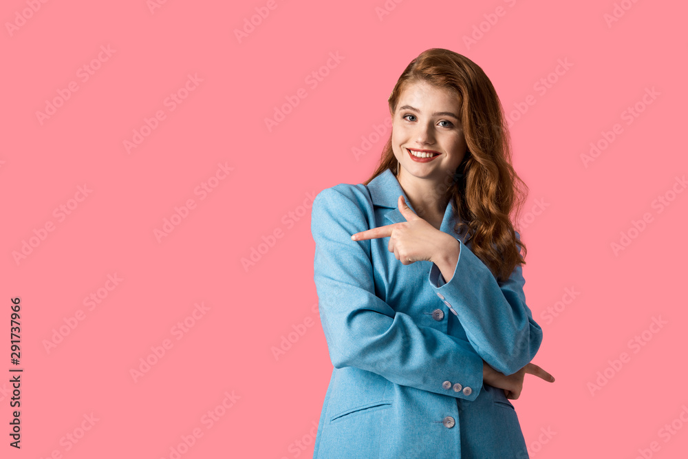 smiling redhead woman pointing with finger isolated on pink smiling redhead woman pointing with finger isolated on pink