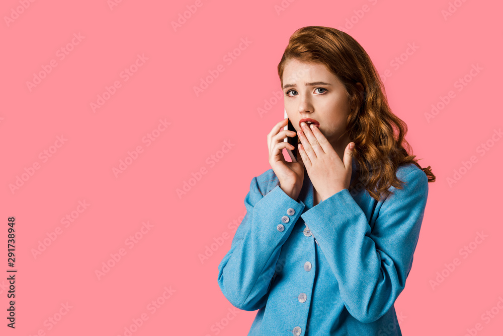 surprised redhead girl talking on smartphone isolated on pink surprised redhead girl talking on smartphone isolated on pink