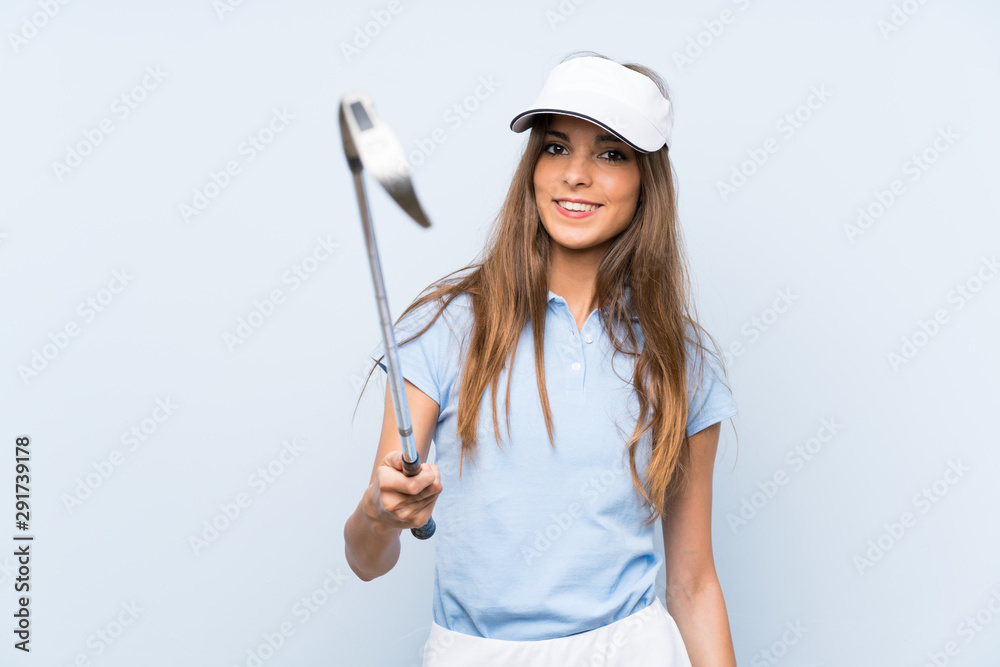 Young golfer woman over isolated blue wall Young golfer woman over isolated blue wall