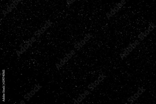 Chaotic white bokeh on a black background, light spots texture, abstraction, falling snow, starry sky, bright glare of light texture