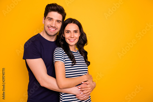 Copyspace photo of nice cute charming beautiful couple rejoicing with each other man hugging woman from back while isolated with yellow background © deagreez