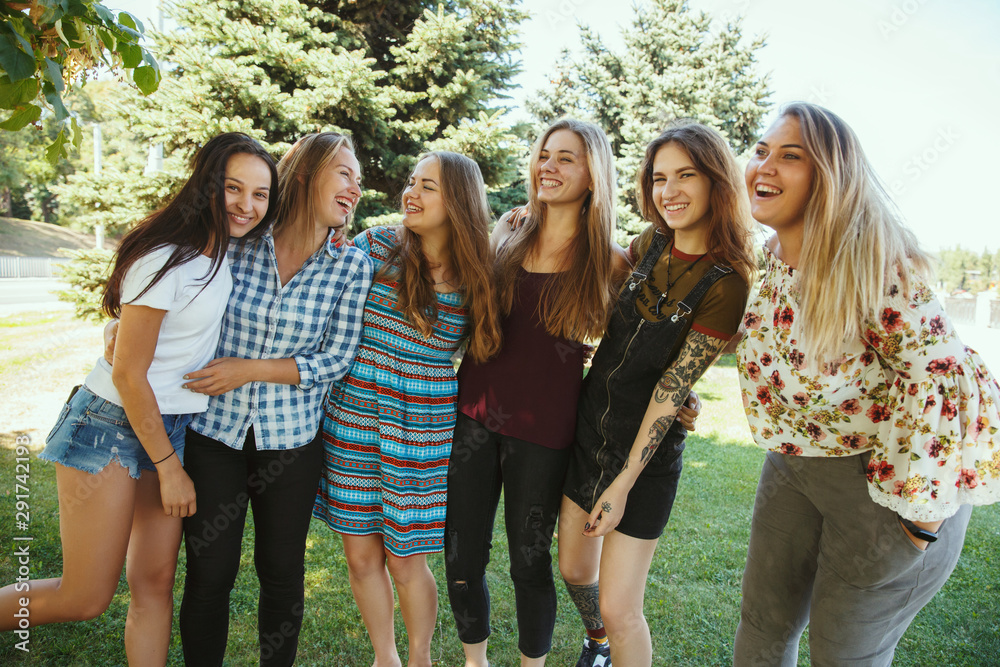 Different and happy in their bodies. Young women smiling, talking, walking and having fun together outdoors on sunny summer's day at park. Girl power, feminism, women's rights, friendship concept. Different and happy in their bodies. Young women smiling, talking, walking and having fun together outdoors on sunny summer's day at park. Girl power, feminism, women's rights, friendship concept.