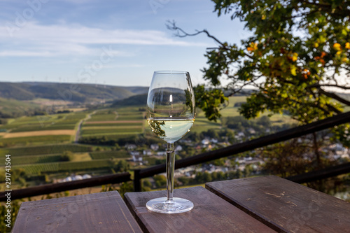 Glas mit Weisswein an einem Aussichtspunkt in Brauneberg an der Mosel photo