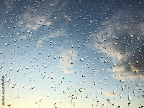Raindrops on transparent glass against the evening sky
