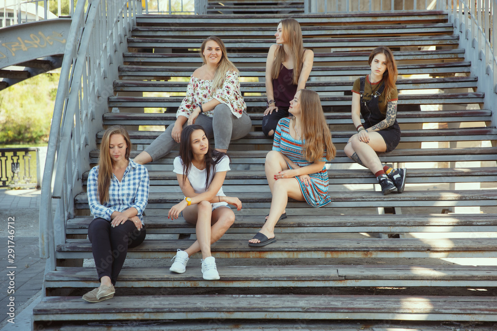 Obraz premium Different and happy in their bodies. Young women smiling, talking, walking and having fun together outdoors on sunny summer's day at park. Girl power, feminism, women's rights, friendship concept.
