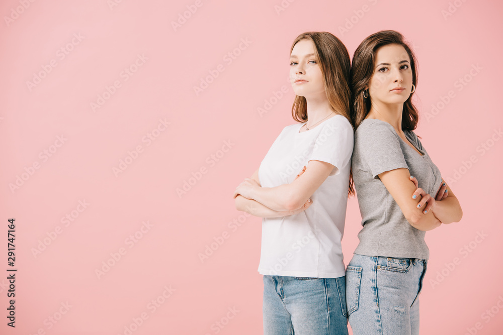 attractive women in t-shirts showing with crossed arms looking at camera isolated on pink attractive women in t-shirts showing with crossed arms looking at camera isolated on pink