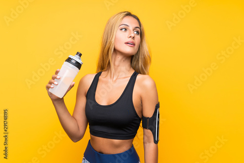 Young sport woman with a bottle of water over isolated background