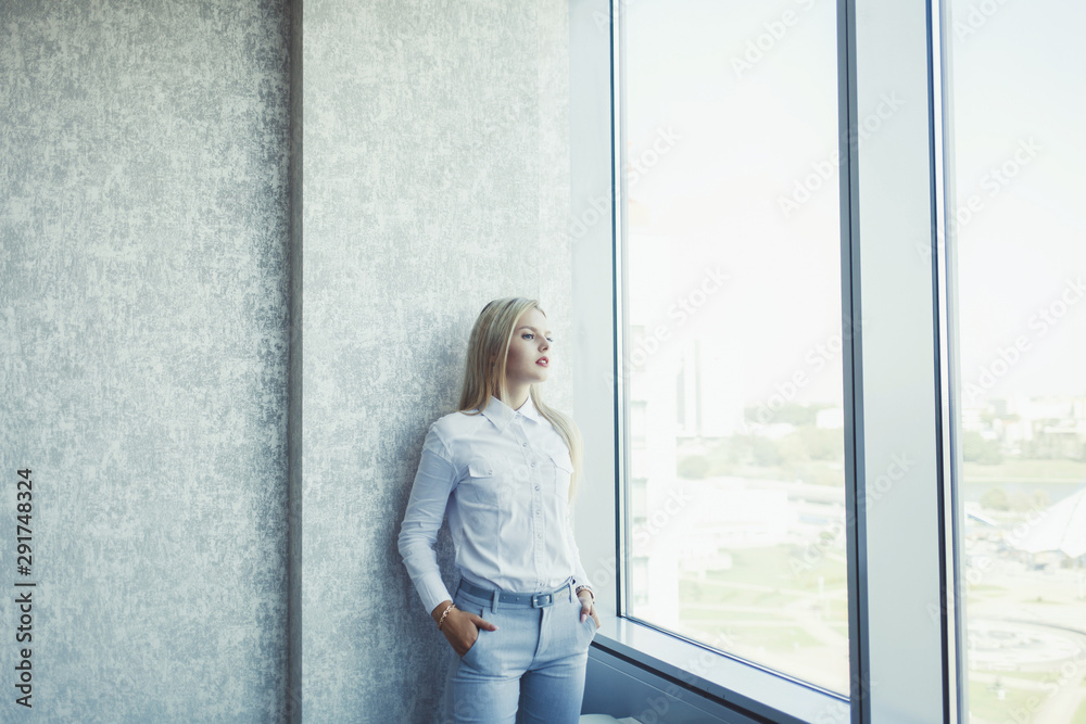business woman wearing formal outfit posing with arms in pockets business woman wearing formal outfit posing with arms in pockets