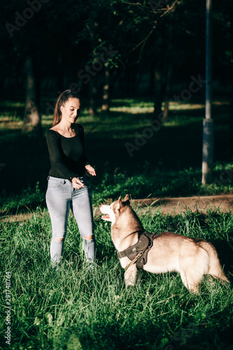 Beautiful woman with playful dog in autumn park