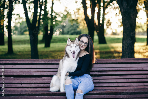 Beautiful girl with a dog  husky in autumn park