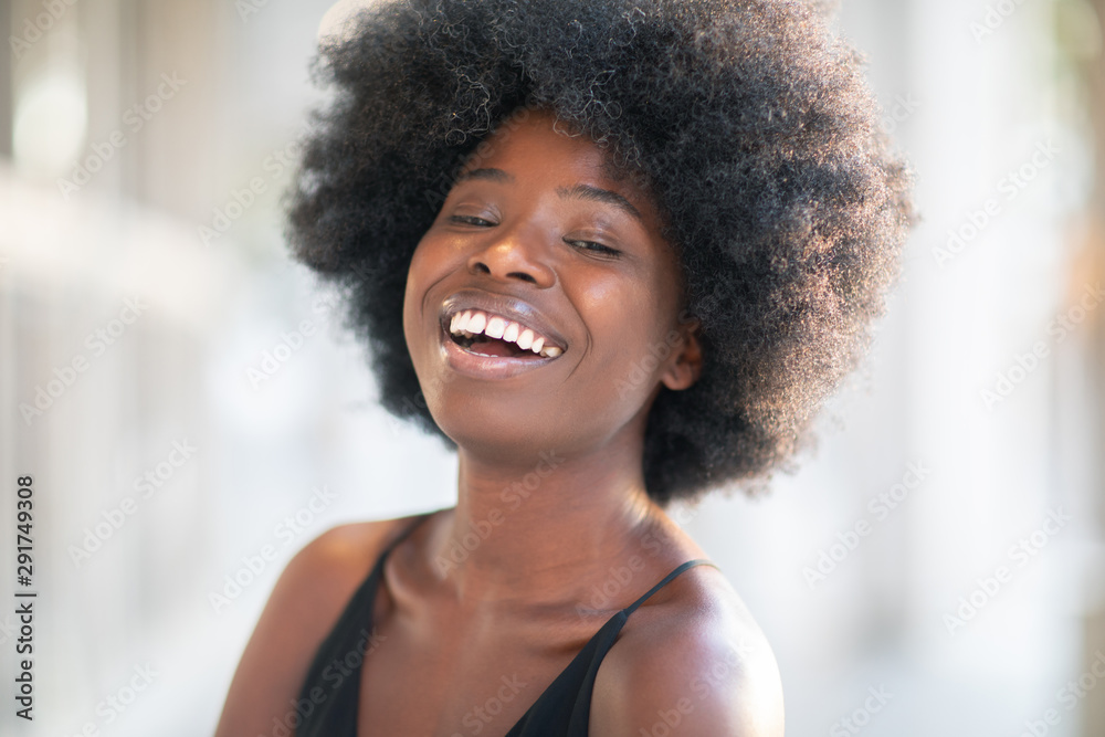 Portrait of smiling young black woman with sunlight flare and copy space Portrait of smiling young black woman with sunlight flare and copy space