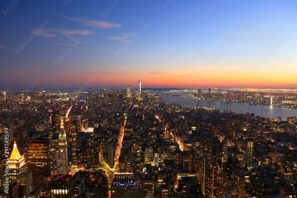 Aerial view of New York City, Lower Manhattan skyline illuminated at sunset, USA