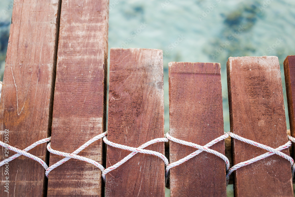 Obraz premium Wooden bridge and rope tied over the sea