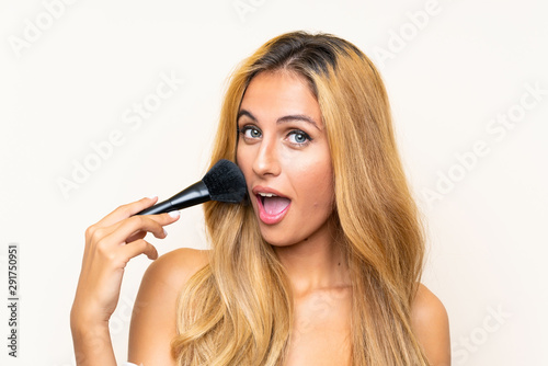 Young blonde woman with makeup brush