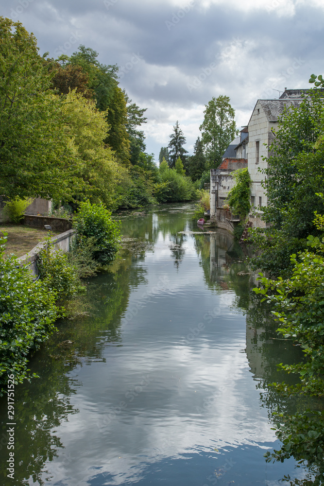 La rivière Indrois coule lentement entre les arbres et les maisons