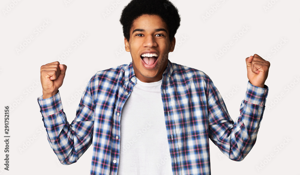 Naklejka premium Black guy screaming Yes and raising clenched fists in the air