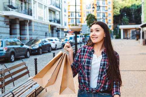 smiling happy girl holding shopping bags on street