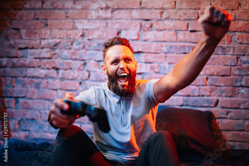 Emotional guy playing video game at home. Concept of gaming and technology. Relax photo