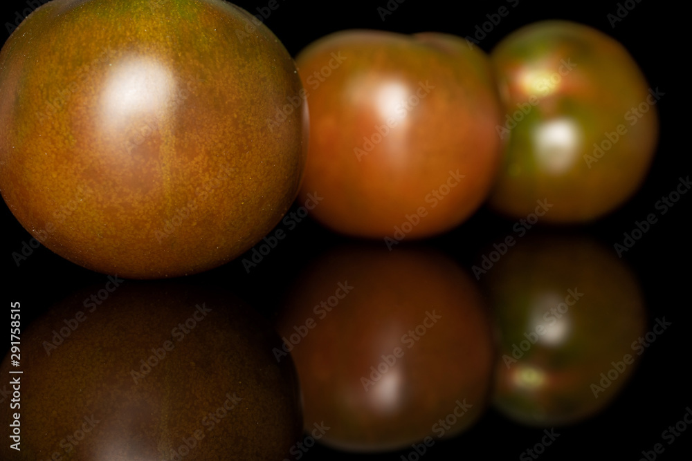 Group of three whole fresh green red tomato isolated on black glass