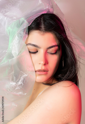 Beautiful plus size body positive brunette girl model wearing comfortable underwear sensually posing with cellophane packaging film. Fashionable, modern design.