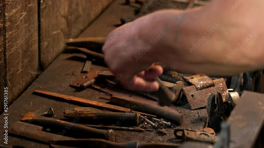 Metal tools of blacksmith are on the tabe. Blacksmith working with a rusty tools in a forge. Blacksmithing concept. Metal tools of blacksmith are on the tabe. Blacksmith working with a rusty tools in a forge. Blacksmithing concept.