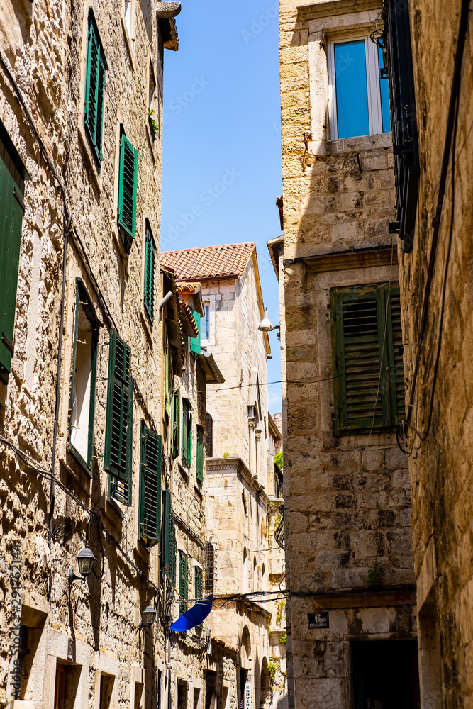 Dalmatian stone houses in the narrow street, stone facades, summer holidays in Split, Dalmatia, Croatia 