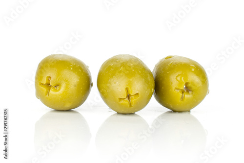 Group of three whole pitted green olive isolated on white background