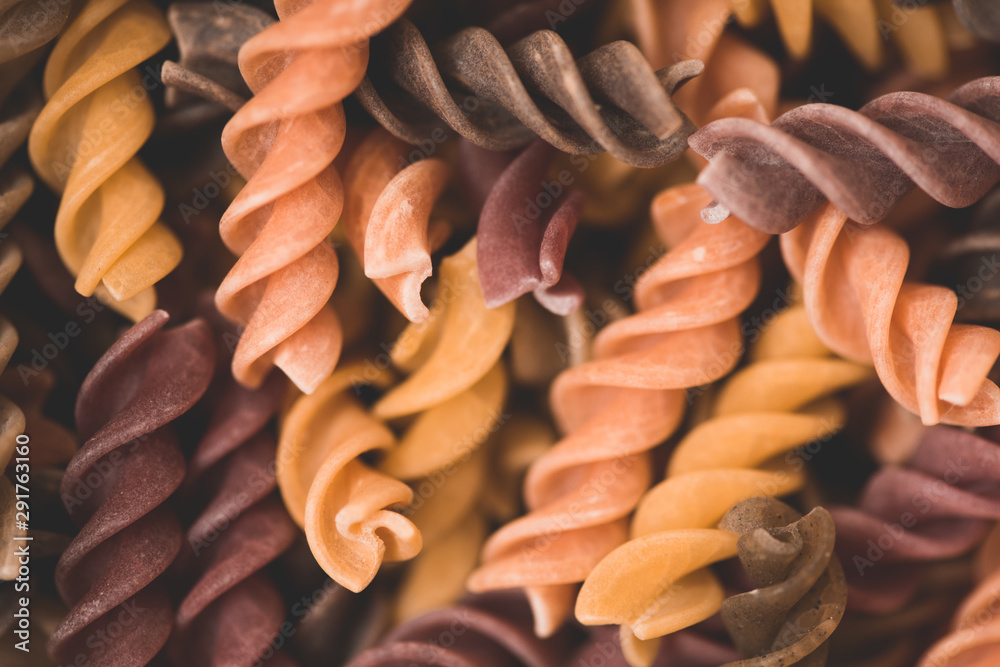 Fusilli pasta in different colors closeup. Cooking delicious dinner. Selective focus. Fusilli pasta in different colors closeup. Cooking delicious dinner. Selective focus.