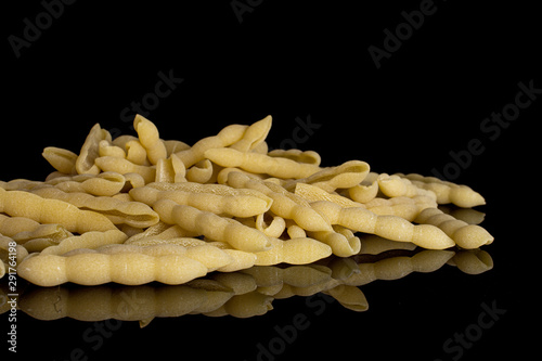 Lot of whole uncooked pasta cavatelli heap isolated on black glass