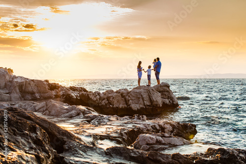 Romantic family portrait on the sunset beach