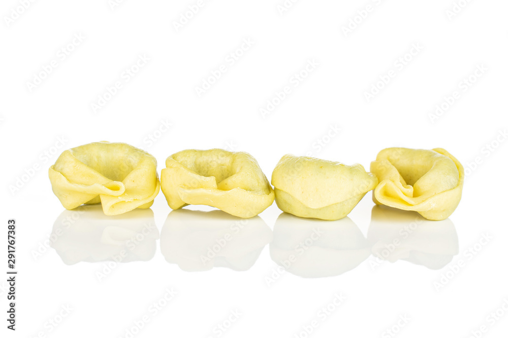 Group of four whole fresh yellow spinach filled tortelloni isolated on white background