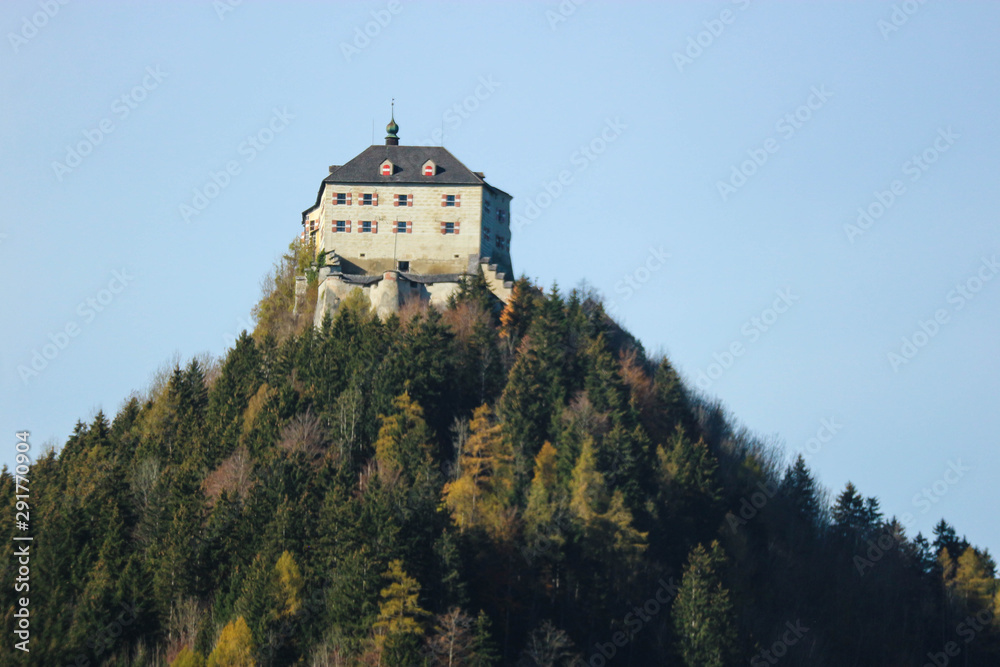 Austrian old castle on the top of the mountain covered by colorful forest