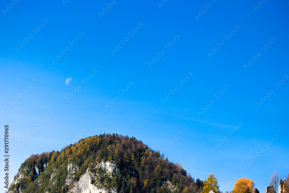 aerial view with the moon above the top of mountain with blue sky background aerial view with the moon above the top of mountain with blue sky background