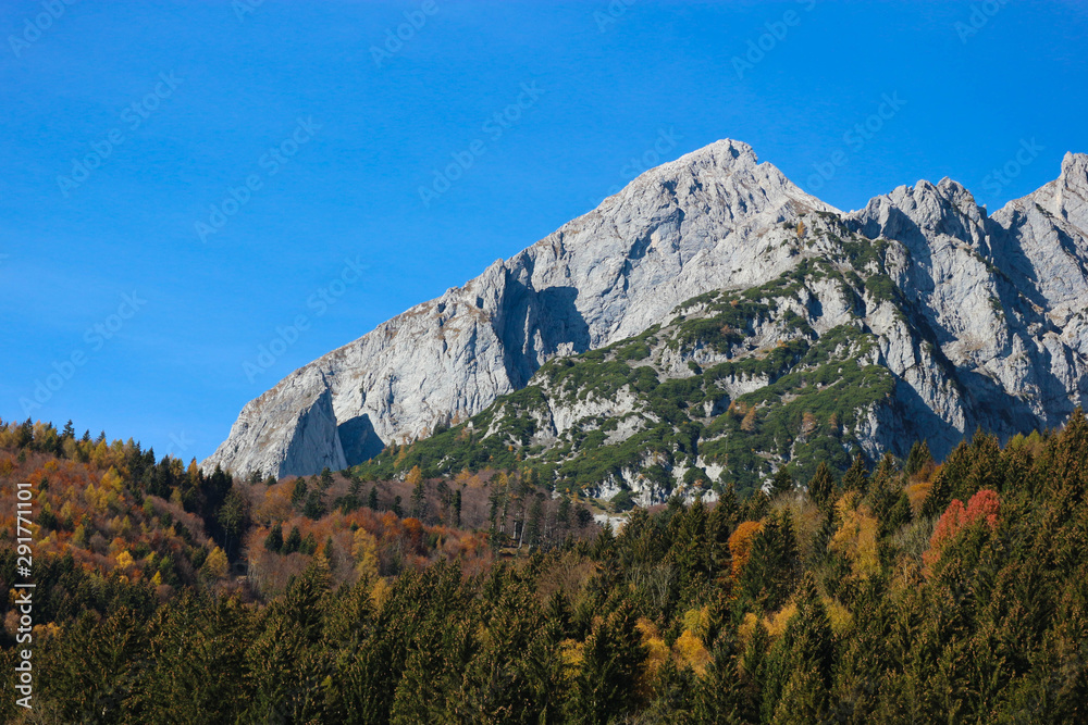 Autumn landscape in alps mountains under blue sky