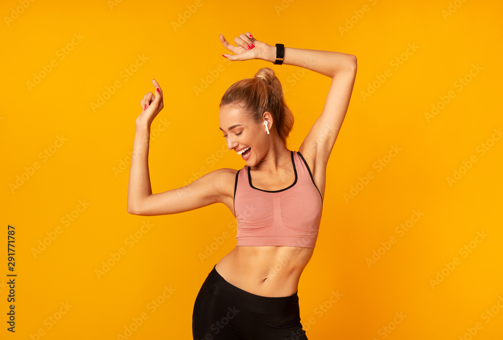 Woman In Wireless Earphones Dancing Listening To Music, Yellow Background - obrazy, fototapety, plakaty 