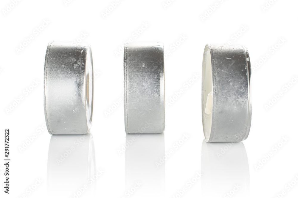 Group of three whole waxy white tea candle isolated on white background