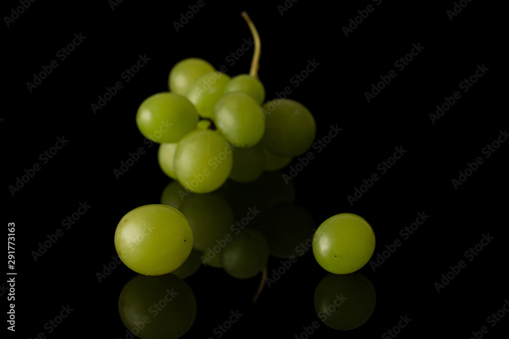 Lot of whole fresh green grape front focus isolated on black glass