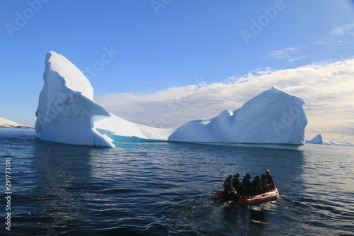 ludzie na łodzi motorowej pomiedzy górami lodowymi wpływający do zatoki u wybrzeży antarktydy
