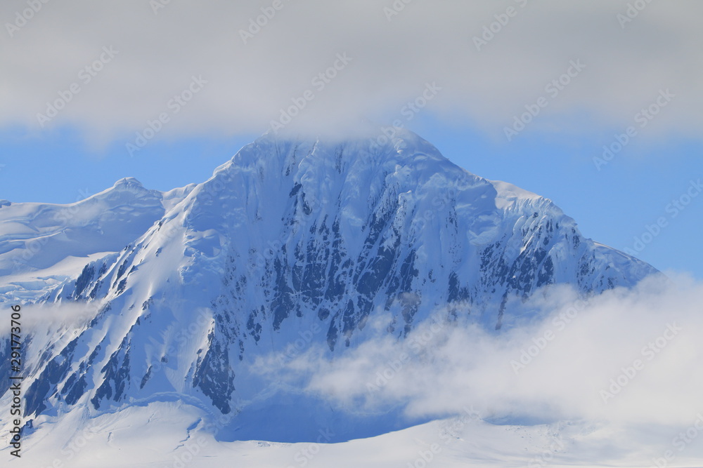 ośnieżona góra ze szczytem w chmurach
