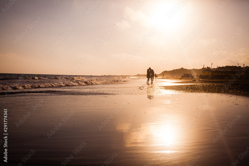 Young romantic couple at the coastline on sunset