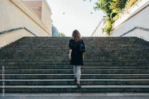 Woman with curly hair climbs the stairs photo