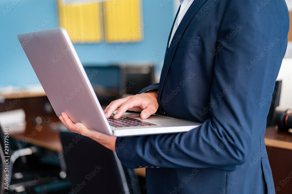 Close-up of businessman using laptop in office Close-up of businessman using laptop in office