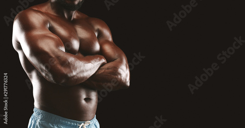 Cropped image of afro bodybuilder with arms crossed