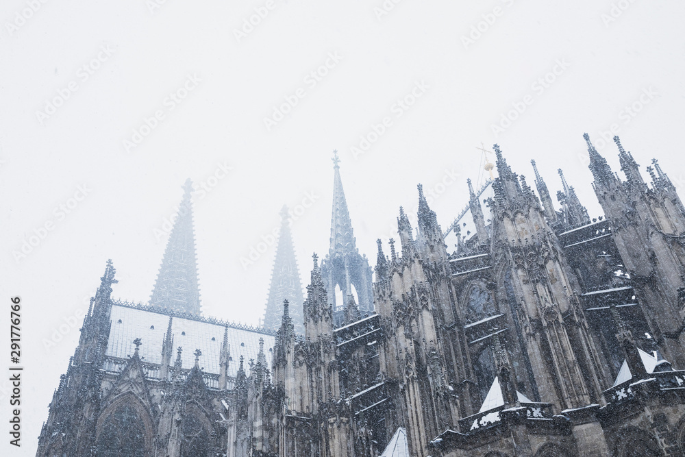 Low angle view of Cologne Cathedral during snowfall against sky Low angle view of Cologne Cathedral during snowfall against sky